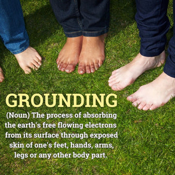 barefoot people on grass with overlayed definition of grounding in terms of earth and electrons