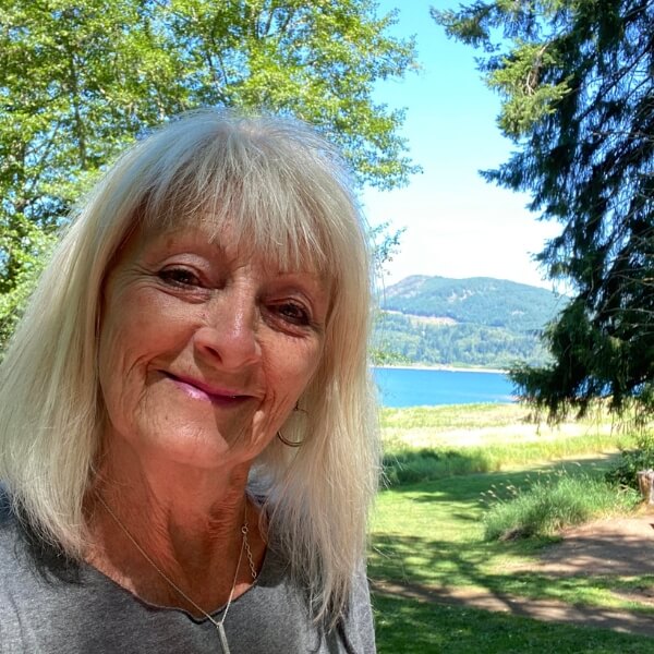 Smiling woman outdoors near a lake